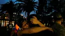 Dua orang pria saling berpelukan di taman setelah teror penembakan di Pulse, klub malam khusus kaum gay di Orlando, Florida, AS, Minggu (12/6). 50 orang tewas dan 53 terluka akibat penembakan yang dilakukan Omar Saddiqui Mateen. (REUTERS/Carlo Allegri)