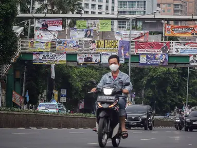 Kendaraan melintas di bawah Jembatan Penyeberangan Orang (JPO) yang tertutup oleh alat peraga kampanye (APK) Pemilu 2024 di Jakarta, Rabu (27/12/2023). (Liputan6.com/Angga Yuniar)