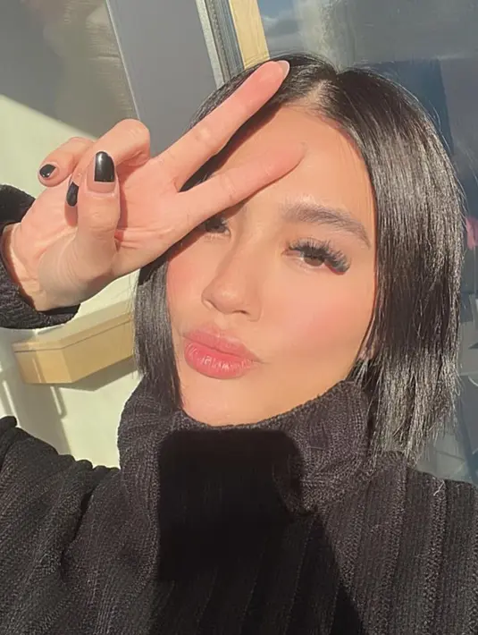 Namun bulu matanya on point, dengan kuteks hitamnya. Dan rambut hitam bergaya bob membingkai wajahnya.  [@agnezmo]