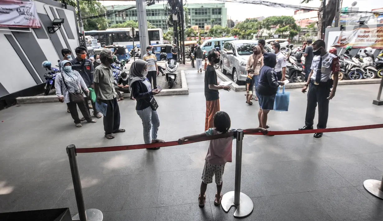 Warga antre untuk mencairkan dana bantuan sosial tunai (BST) di ATM Bank DKI kawasan Matraman, Jakarta, Rabu (21/7/2021). Pemprov DKI Jakarta menyalurkan BST di masa Pemberlakukan Pembatasan Kegiatan Masyarakat (PPKM) Darurat kepada 907.606 kepala keluarga (KK). (merdeka.com/Iqbal S. Nugroho)