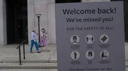 Sejumlah pengunjung yang mengenakan masker meninggalkan Gedung Barat Galeri Seni Nasional di Washington DC, AS (20/7/2020). Sebagian galeri tersebut dibuka kembali untuk umum pada Senin (20/7) setelah ditutup selama berbulan-bulan akibat pandemi COVID-19. (Xinhua/Liu Jie)