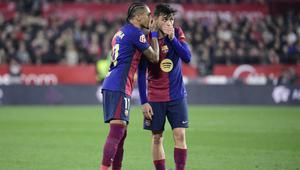 Pemain depan Barcelona asal Brasil #11, Raphinha, berbicara dengan gelandang Barcelona asal Spanyol #08, Pedri (Kanan), selama pertandingan liga Spanyol antara Sevilla FC dan FC Barcelona di Stadion Ramon Sanchez Pizjuan di Seville, Senin dini hari WIB (9-2-2025). (CRISTINA QUICLER/AFP)