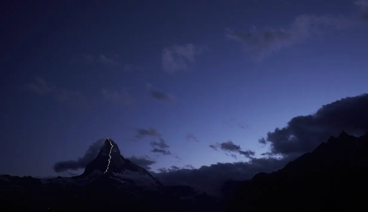 Suasana gunung Matterhorn dari kejauhan, saat rangkaian lampu dinyalakan, Zermatt, Swiss, Senin (13/7/2015). Briton merupakan orang yang pertama kali mendaki gunung ini, dengan dibantu oleh 6 tim pendaki. (REUTERS/Denis Balibouse)