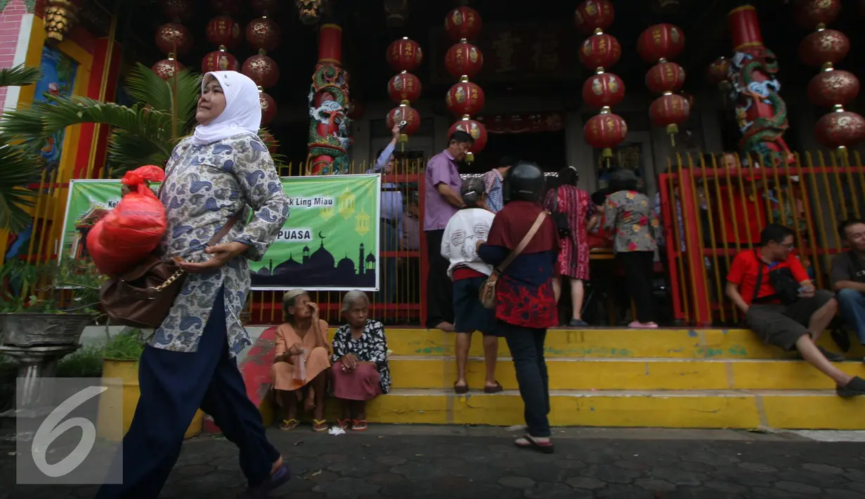 Seorang warga membawa sembako yang di bagikan oleh warga keturunan Tionghoa di Klenteng Fuk Ling Miau, Yogyakarta, Jumat (1/7). Pembagian sembako dilakukan sebagai bentuk kepedulian terhadap sesama di bulan ramadan. (Liputan6.com/Boy Harjanto)