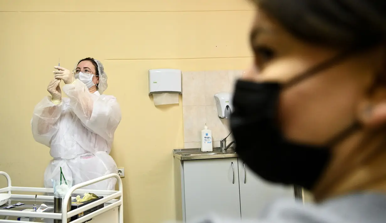 Perawat bersiap menyuntikkan vaksin corona Sputnik V di tengah pandemi yang berlangsung di sebuah klinik di Moskow, Sabtu (5/12/2020). Presiden Rusia Vladimir Putin memerintahkan pihak berwenang memulai vaksinasi massal untuk orang-orang berisiko tinggi tertular Covid-19. (Kirill KUDRYAVTSEV/AFP)