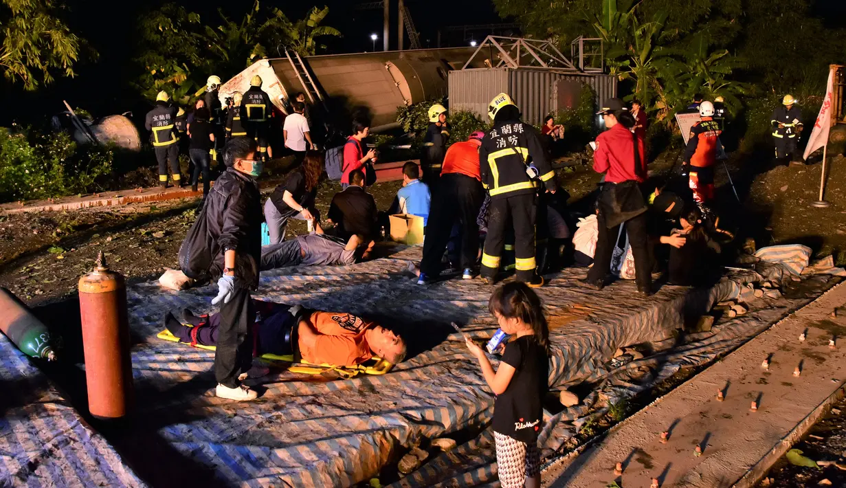 Petugas penyelamat menyelamatkan korban tergelincirnya kereta Puyuma Express di Yilan, Taiwan, Minggu (21/10). Sejauh ini belum diketahui pasti apa yang menyebabkan kereta itu tergelincir. (AP Photo)