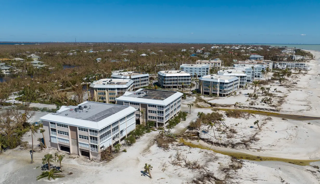 Air mengalir melewati bangunan di tepi laut setelah Badai Ian melewati daerah itu, Pulau Sanibel, Florida, Amerika Serikat, 30 September 2022. Badai Ian yang menerjang Kuba lalu Florida, kini menyeberang ke Samudra Atlantik dan bergejolak ke arah Carolina Selatan. (AP Photo/Steve Helber)