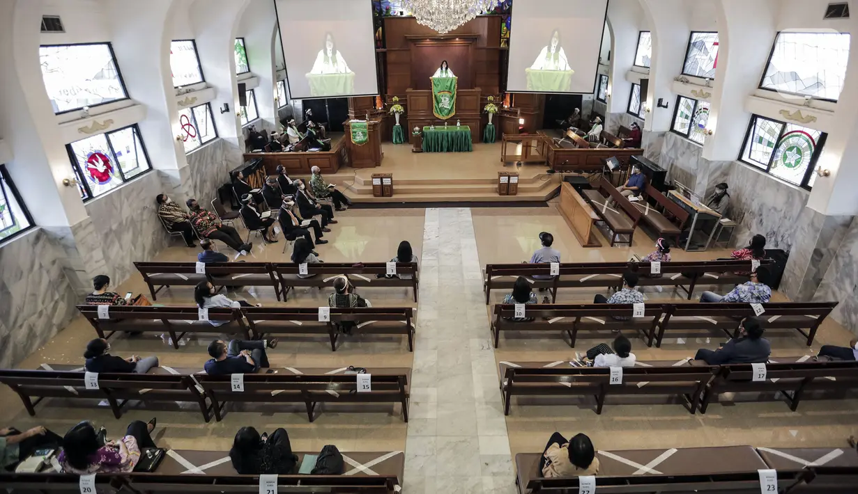 Jemaat menerapkan jaga jarak aman saat mengikuti misa di Gereja Protestan Indonesia Bagian Barat (GPIB) Effatha, Jakarta, Minggu (5/7/2020). GPIB Effatha membatasi jumlah jemaat menjadi 30 persen serta mewajibkan mencuci tangan, menggunakan masker, dan jaga jarak aman. (Liputan6.com/Johan Tallo)