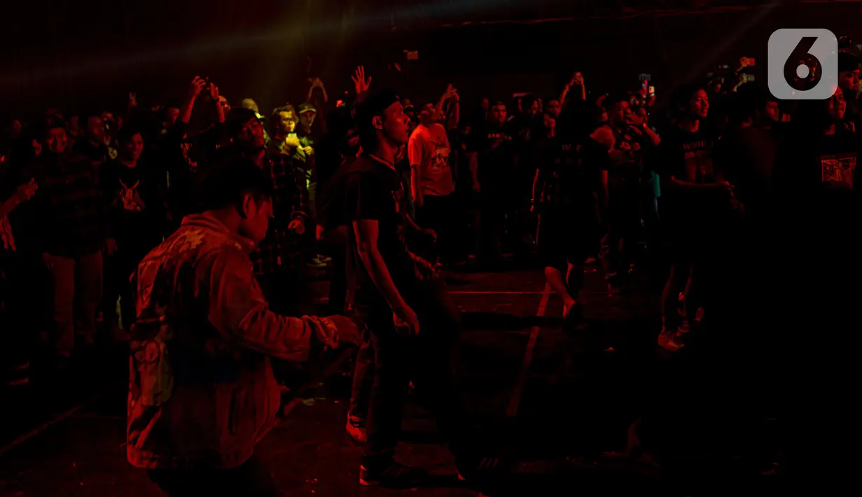 Para penonton berjoget bersama saat menyaksikan salah satu band metal dalam konser offline di kawasan Jakarta, Minggu (22/5/2022). Konser musik offline kembali diizinkan seiring dengan pelonggaran aturan penggunaan masker di luar ruangan. (Liputan6.com/Faizal Fanani)