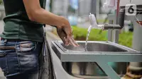 Pengguna jalan mencuci tangan ditempat yang telah disediakan Pemprov DKi Jakarta di kawasan Pedestrian Ratu Plaza, Jakarta, Senin (23/2/2020). Sarana cuci tangan ini tersedia 12 unit dan tersebar di wilayah DKI Jakarta. (Liputan6.com/Faizala Fanani)