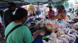 Penjual melayani pembeli makanan untuk berbuka puasa (takjil) di kawasan Pasar Lama, Kota Tangerang, Selasa (20/4/2021). Bulan Ramadhan, membuat sejumlah pedagang takjil musiman bermunculan dan menawarkan aneka makanan dan minuman untuk umat Islam yang menjalankan puasa. (Liputan6.com/Angga Yuniar)