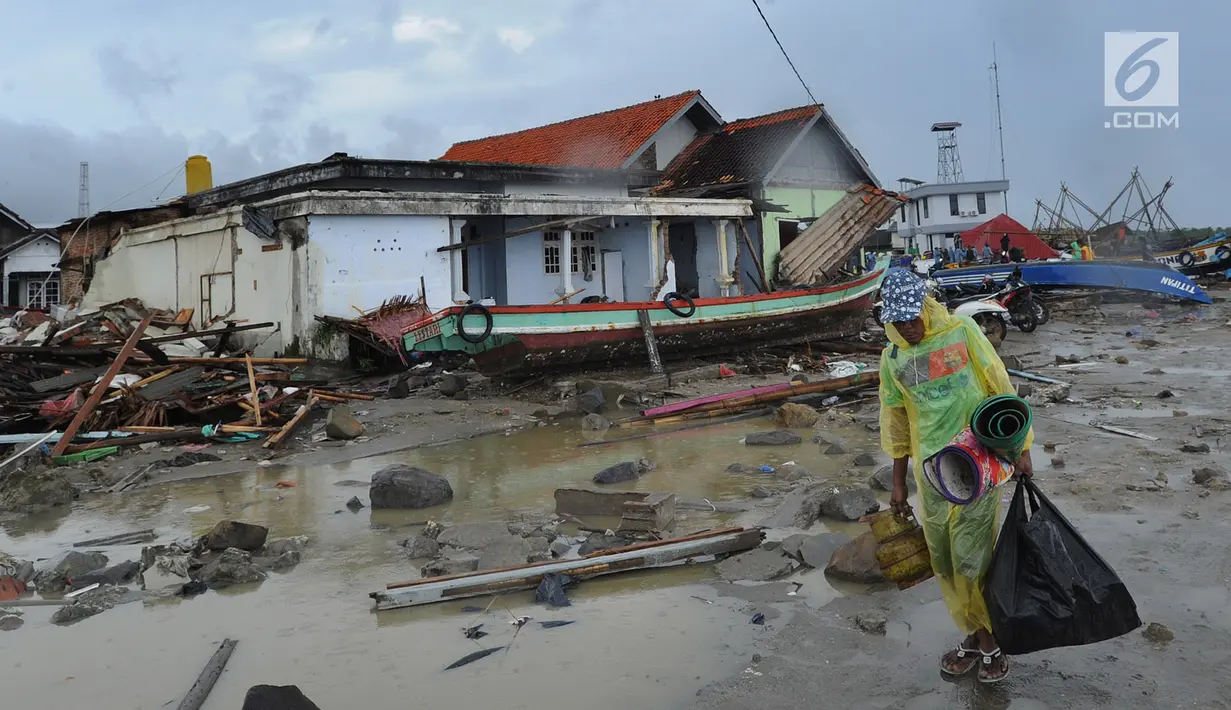 Warga membawa perkakas dari bangunan rumahnya yang rusak akibat terjangan tsunami di Kampung Sumur Pesisir, Pandeglang, Banten, Senin (24/12). Pascatsunami Selat Sunda, warga mulai kembali ke rumahnya masing-masing. (Merdeka.com/Arie Basuki)