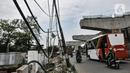 Kendaraan melintas dekat instalasi kabel yang semrawut di Jalan Raya Bekasi, Cakung, Jakarta, Rabu (30/9/2020). Minimnya perawatan pascapembebasan lahan permukiman untuk proyek Tol Dalam Kota membuat jaringan kabel listrik di sepanjang jalan tersebut semrawut. (merdeka.com/Iqbal S. Nugroho)