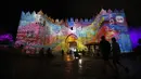Orang-orang berjalan di dekat gerbang Damaskus selama festival cahaya di kota tua Yerusalem, 28 Juni 2018. Festival cahaya yang menampilkan karya seniman Israel dan internasional ini berlangsung setiap tahun di Kota Tua Yerusalem. (AFP / Ahmad GHARABLI)