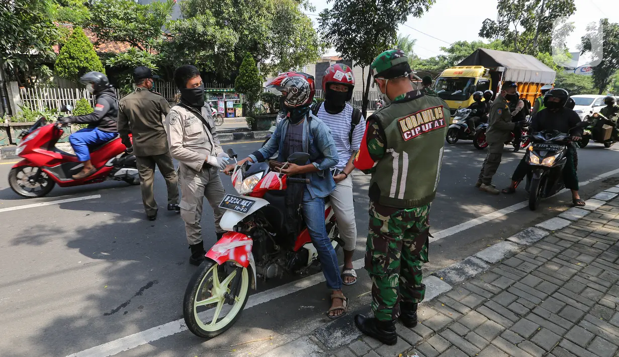 Petugas memeriksa identitas pengendara bermotor pada hari pertama Pemberlakuan Pembatasan Sosial Berskala Besar (PSBB) di jalur check point Jalan Ir. H Juanda, Ciputat, Tangerang Selatan, Sabtu (18/4/2020). Selama PSBB pengendara wajib kenakan masker dan sarung tangan. (Liputan6.com/Fery Pradolo)