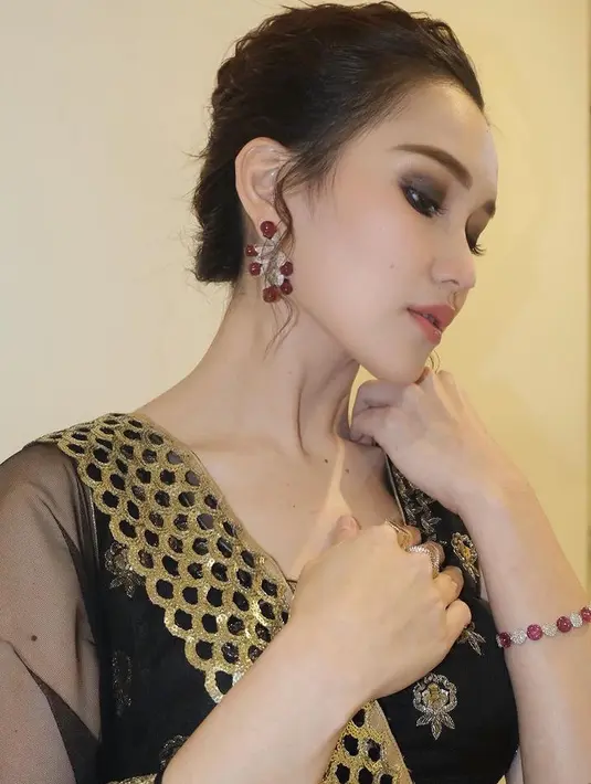 Rambutnya pun disanggul modern tanpa menyisakan poni, yang membuat anting-anting warna maroon silvernya tampak terlihat. Serta mengenakan gelang warna serasi dengan anting [@ayutingting92]
