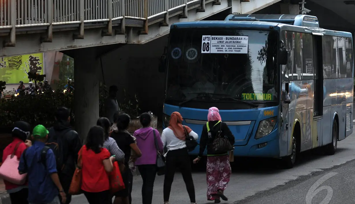 Para penumpang di depan bus Angkutan Perbatasan Terintegrasi Busway (APTB) di kawasan Kuningan Barat, Jakarta, Rabu (7/1). (Liputan6.com/Miftahul Hayat)