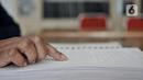 Penyandang tunanetra meraba huruf braille saat membaca buku di Perpustakaan Yayasan Mitra Netra, Jakarta, Selasa (3/12/2019). Perpustakaan Mitra Netra menyajikan buku-buku khusus penyandang tunanetra, seperti buku braille, buku audio digital, dan buku elektronik. (merdeka.com/Iqbal S Nugroho)