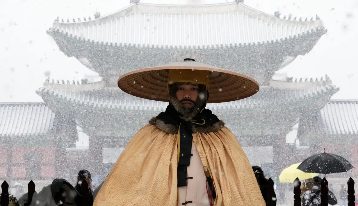 Seorang penjaga Kekaisaran berdiri di tengah salju di luar Istana Gyeongbok, istana kerajaan utama selama Dinasti Joseon dan salah satu landmark terkenal Korea Selatan di Seoul, Korea Selatan, 15 Desember 2022. (AP Photo/Ahn Young-joon)