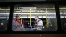 Dua orang terlihat dari kaca jendela bus yang pecah ketika dalam perjalanan menuju pusat media centre di Barra da Tijuca, Selasa (9/8). Bus yang mengangkut para jurnalis di Olimpiade Rio 2016 itu ditembak orang tak dikenal. (REUTERS/Adrees Latif)