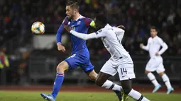 Gelandang Islandia, Gylfi Sigurdsson, berusaha melewati gelandang Prancis, Blaise Matuidi, pada laga Kualifikasi Piala Eropa 2020 di Reykjavik, Sabtu (11/10). Islandia kalah 0-1 dari Prancis. (AFP/Jonathan Nackstrand)