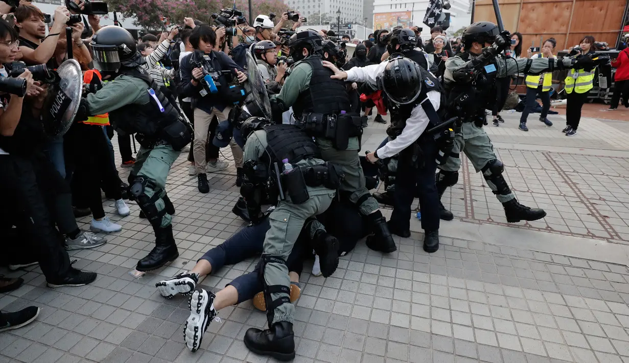 Polisi antihuru-hara menangkap demonstran saat unjuk rasa untuk menunjukkan dukungan kepada Uighur dan perjuangan mereka terhadap hak azasi manusia di Hong Kong, Minggu (22/12/2019). Demonstran memprotes kebijakan China terkait minoritas Uighur. (AP Photo/Lee Jin-man)