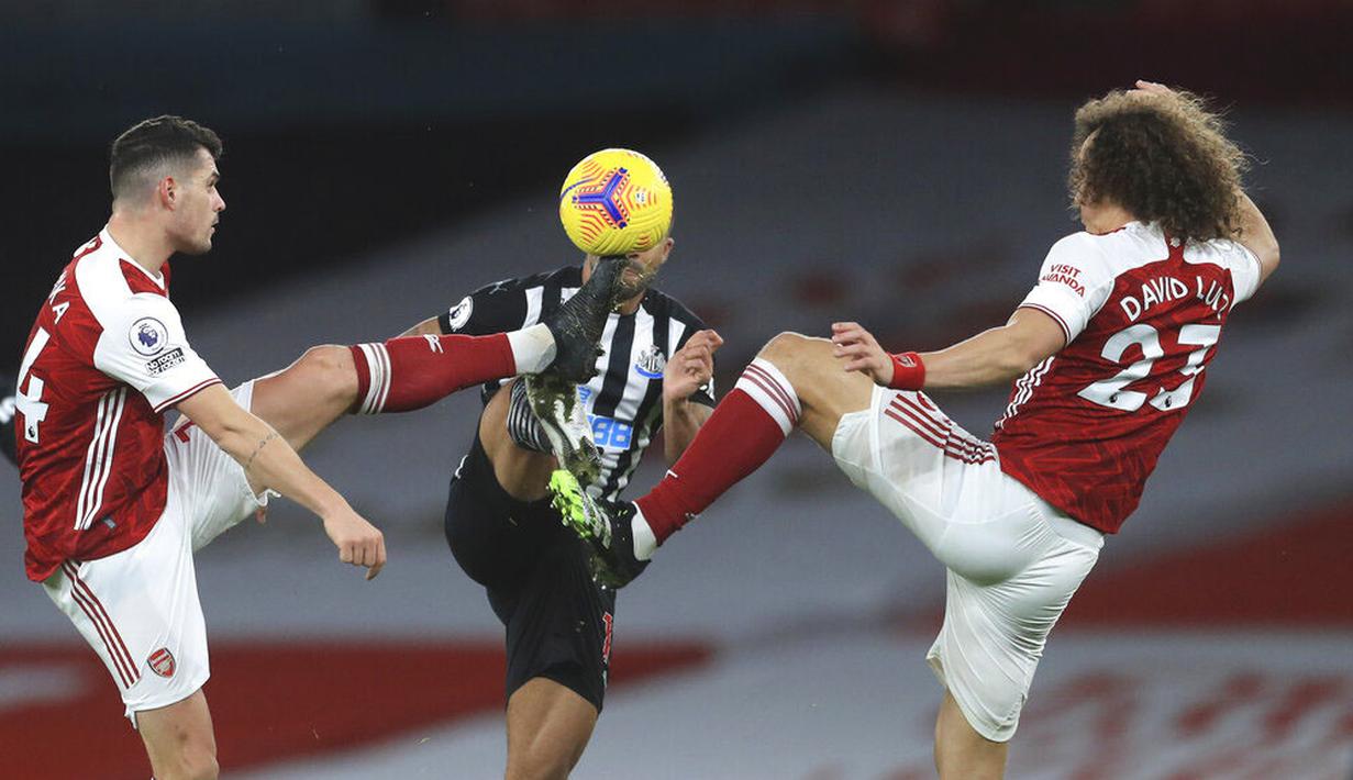 Pemain Arsenal, Granit Xhaka dan David Luiz, berebut bola dengan pemain Newcastle United, Callum Wilson, pada laga Liga Inggris di Stadion Emirates, Senin (18/1/2021). Arsenal menang dengan skor 3-0. (Adam Davy/Pool via AP)