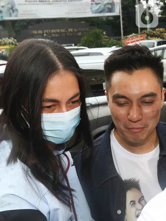Pasangan selebritis Baim Wong dan Paula Verhoeven saat tiba di polres Jakarta Selatan, Jumat (7/10/2022). Baim mengenakan jaket jeans dilapis kaos warna putih bergambar karikatur anaknya. (Liputan6.com/Herman Zakharia)
