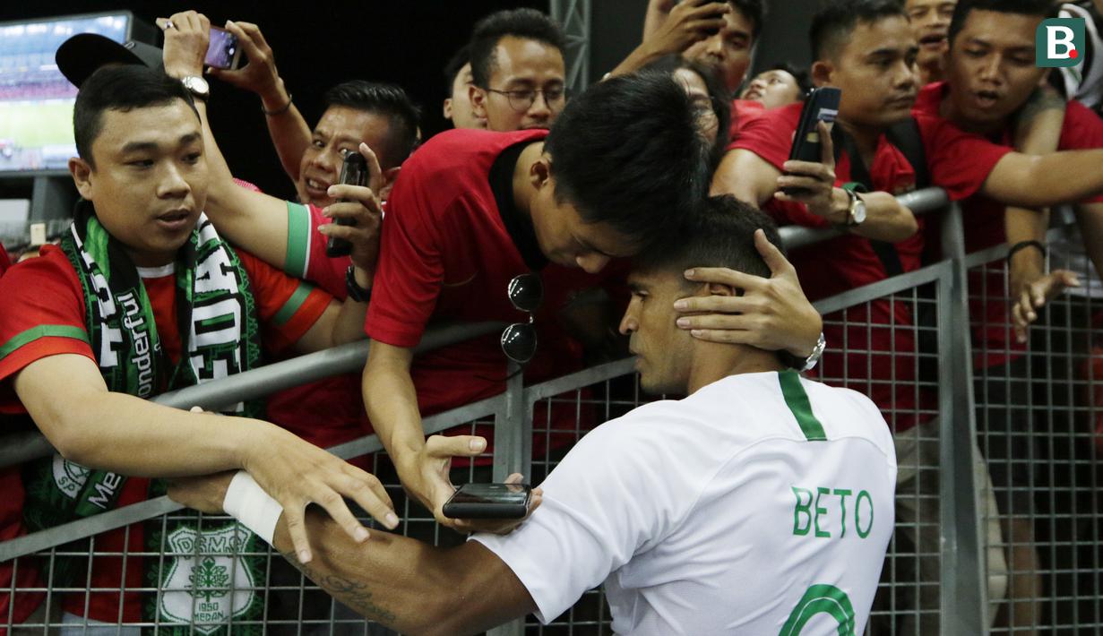Seorang suporter memeluk striker Timnas Indonesia, Beto Goncalves, usai dikalahkan Singapura pada laga Piala AFF di Stadion Nasional, Singapura, Jumat (9/11). Singapura menang 1-0 atas Indonesia. (Bola.com/M. Iqbal Ichsan)