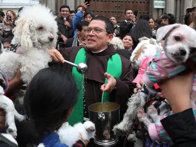Imam Katolik Fermin Pena  melakukan pemberkatan pada hewan peliharaan dengan air suci di luar gereja San Francisco di Lima, Peru, Minggu (6/10/2019). Pemberkatan hewan ini untuk menghormati Santo Fransiskus yang dikenal sebagai santo pelindung bagi binatang dan lingkungan hidup. (AP/Martin Mejia)
