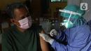 Tenaga kesehatan menyuntikan vaksin kepada warga di MTs As-Syafiiyah, Cilangkap, Jakarta, Kamis (3/6/2021). Vaksinasi akan menyasar sekitar 400 warga RT 03 RW 03 Cilangkap. (Liputan6.com/Herman Zakharia)