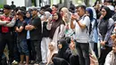 Warga menyaksikan sebelas pria dan wanita menjalani hukuman cambuk setelah dinyatakan bersalah melanggar hukum syariat Islam Aceh yang melarang hubungan seksual di luar nikah di Banda Aceh, Kamis, 20 Agustus 2026. (AFP/ Chaideer Mahyuddin)