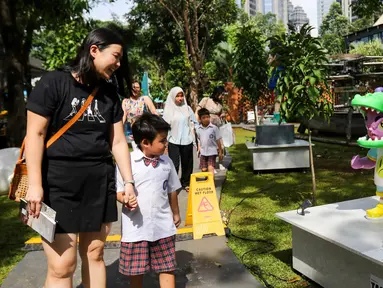 Pengunjung melihat-lihat karya seni instalasi pada pameran Art Jakarta Gardens di Hutan Kota Plataran, Senayan, Jakarta, Rabu (23/4/2025). (Liputan6.com/Herman Zakharia)