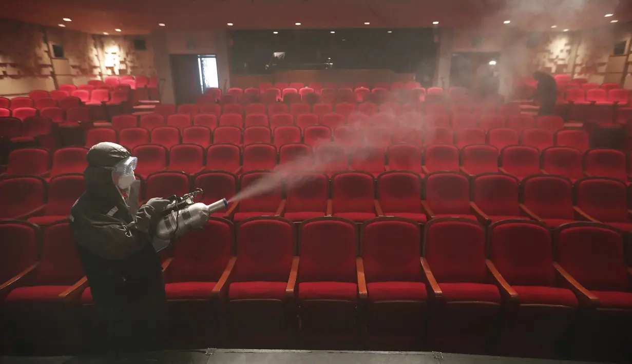 Pekerja mengenakan alat pelindung diri saat melakukan penyemprotan disinfektan sebuah teater di Sejong Center, Seoul, Korea Selatan, Selasa (21/7/2020). Kasus COVID-19 di Korea Selatan kembali meningkat setelah sempat dinyatakan menurun. (AP Photo/Ahn Young-joon)