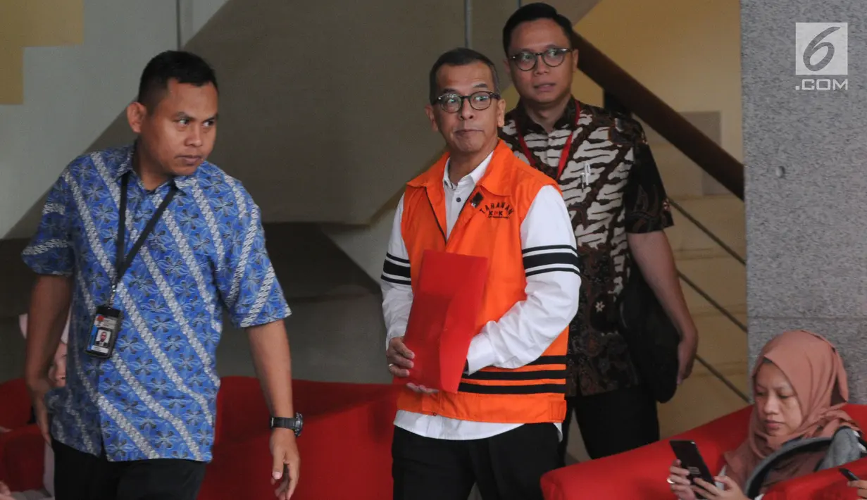 Mantan Dirut PT Garuda Indonesia Emirsyah Satar (tengah) menutupi borgol di tangannya dengan map merah saat akan menjalani pemeriksaan di Gedung KPK, Jakarta, Jumat (16/8/2019). Ini merupakan pemeriksaan perdana Satar pascaditahan oleh penyidik KPK. (merdeka.com/Dwi Narwoko)