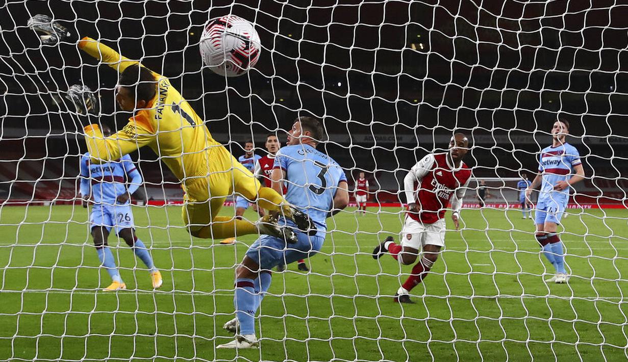 Penyerang Arsenal, Alexandre Lacazette, mencetak gol ke gawang West Ham United pada laga Premier League di Stadion Emirates, Sabtu (19/9/2020). Arsenal menang dengan skor 2-1. (Julian Finney/Pool via AP)