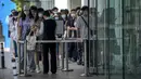 Karyawan yang mengenakan masker menunggu hasil tes COVID-19 mereka diperiksa untuk memasuki gedung perkantoran di kawasan pusat bisnis di Beijing, China, Selasa (31/5/2022). Penguncian COVID-19 di Shanghai telah mencekik ekonomi nasional dan sebagian besar mengurung jutaan orang di rumah mereka. (AP Photo/Mark Schiefelbein)