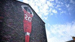 Mural bergambar mendiang Diogo Jota yang tengah membuat simbol hati dengan tangannya terlihat di dinding perumahan dekat Stadion Anfield, Liverpool, Inggris, Senin (11/08/2025) waktu setempat. Karya tersebut dibuat oleh seniman bernama MurWalls. (AFP/Paul Ellis)