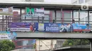 Pejalan kaki melintasi jembatan penyeberangan orang (JPO) yang dipasangi  Alat Peraga Kampanye (APK) di kawasan Salemba, Jakarta, Kamis (7/12/2023).  (Liputan6.com/Herman Zakharia)