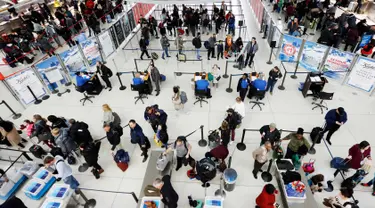 Wisatawan mengantre untuk melewati pos pemeriksaan keamanan di Bandara Internasional John F. Kennedy, New York, Rabu (21/11). Masyarakat Amerika mulai bergegas pulang ke kampung halamannya alias mudik untuk merayakan Thanksgiving Day. (AP/Mark Lennihan)