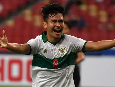 Pemain Indonesia Witan Sulaeman melakukan selebrasi usai mencetak gol ke gawang Singapura pada pertandingan leg pertama semifinal Piala AFF 2020 di National Stadium, Singapura, Rabu (22/12/2021). Pertandingan berakhir imbang 1-1. (Roslan RAHMAN/AFP)