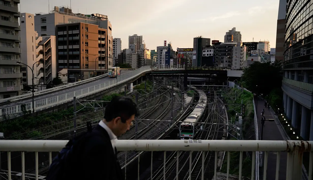 Seorang pria berjalan di jembatan saat kereta Yamanote Line berangkat dari Stasiun Ikebukuro di Tokyo, Jepang, Rabu (22/5/2019). (AP Photo/Jae C. Hong)