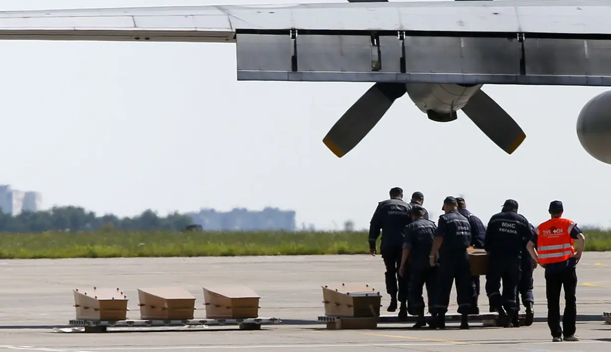 Beberapa peti jenasah korban jatuhnya pesawat Malaysia Airlines MH-17 diletakkan berjajar sesaat sebelum diangkut menuju Belanda di Bandara Kharkiv, (23/7/2014). (REUTERS/Gleb Garanich)