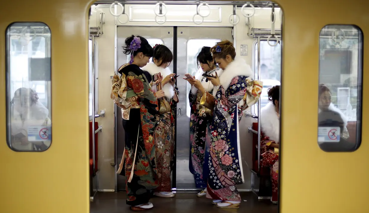Wanita Jepang berkimono menaiki kereta usai mengikuti upacara Coming of Age Day (Hari Kedewasaan Nasional) di taman hiburan Tokyo, Senin (11/1). Hari Kedewasaan Nasional ini dirayakan para muda-mudi Jepang yang menginjak usia 20 tahun (REUTERS/Yuya Shino)
