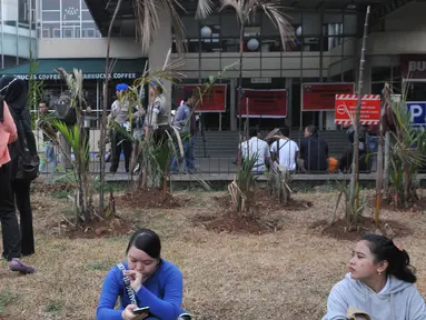 Sejumlah pegawai oulet tertegun menyaksikan penyegelan Mal Tebet Green, Jakarta, Kamis (23/7/15). Pegawai khawatir perusahaannya akan memutuskan hubungan kerja secara sepihak usai kejadian ini. (Liputan6.com/Herman Zakharia)