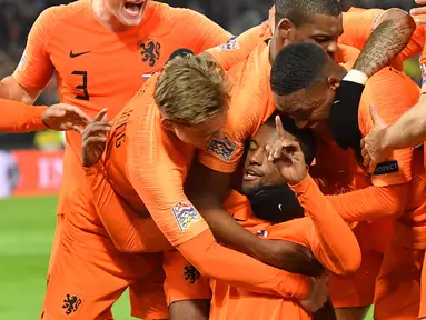 Gelandang Belanda, Georginio Wijnaldum (tengah) berselebrasi usai mencetak gol ke gawang Prancis pada pertandingan UEFA Nations League di stadion Feijenoord di Rotterdam (16/11). Belanda menang atas Prancis 2-0. (AFP Photo/Emmanuel Dunand)