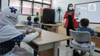 Seorang wanita menyampaikan penjelasan mengenai menabung sejak dini kepada murid kelas III saat pembagian Tabungan Simpanan Pelajar (Simpel) di SDN Pondok Labu 07, Jakarta, Kamis (10/3/2022). Pembagian tabungan untuk mendukung program OJK terkait One Student One Account. (merdeka.com/Arie Basuki)