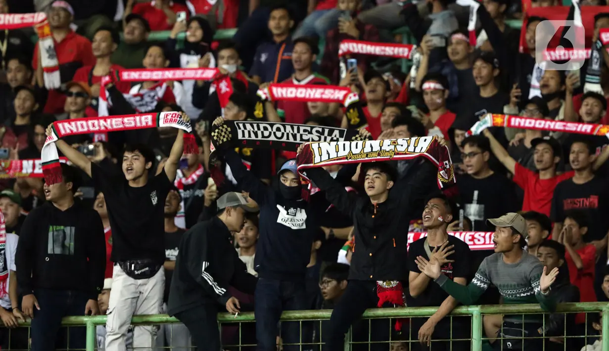Suporter membentangkan syal saat merayakan kemenangan Timnas Indonesia U-19 atas Filipina U-19 pada lanjutan penyisihan grup A Piala AFF U-19 2022 di Stadion Patriot Candrabhaga, Bekasi, Jawa Barat, Jumat (8/7/2022). Timnas Indonesia U-19 tampil menyerang dan unggul 5-1 atas Filipina U-19. (Liputan6.com/Helmi Fithriansyah)