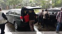 Usai menggeledah rumah dinas bupati Bangkalan, penyidik KPK memasukkan koper merah ke bagasi mobil. (Musthofa Aldo)