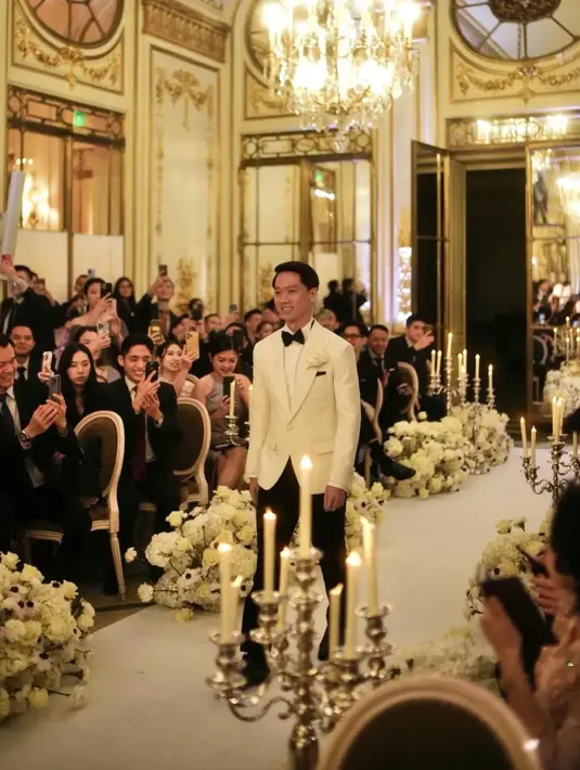 Kevin Sanjaya tampak gagah menuju altar pernikahan. Tampak jalan menuju altar juga dihias dengan bunga putih dan lilin. [Instagram/diah_kss]